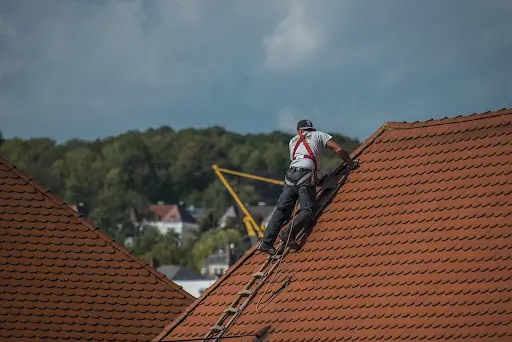 worker checking tile roofing